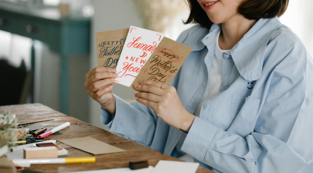A girl smiling while reading new year wishes on a card.