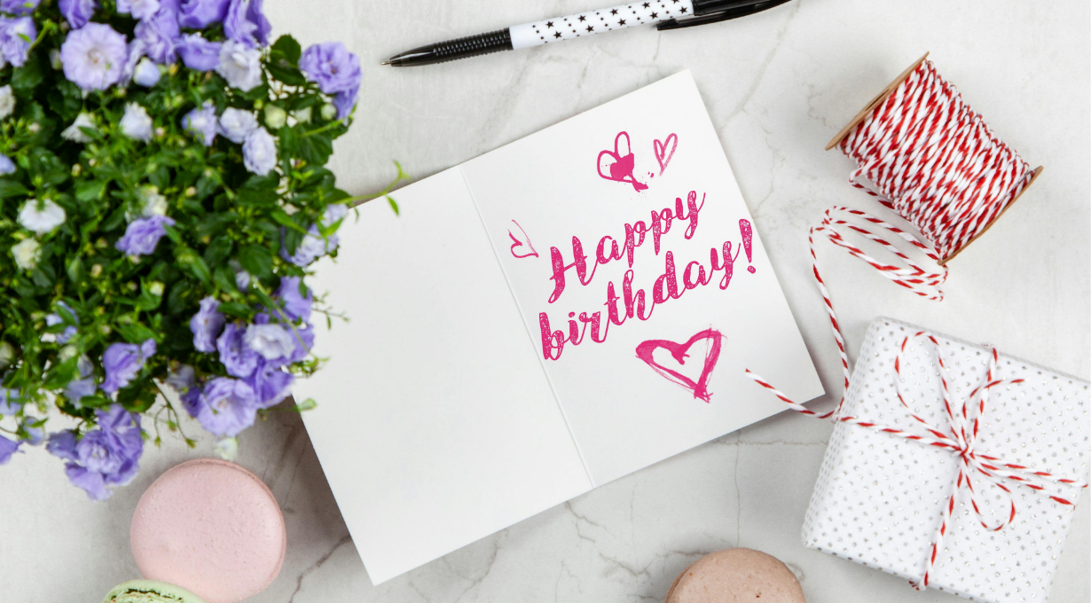 Happy birthday wishes for him written on a card with flowers