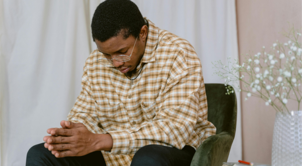 A man saying a prayer for a job interview before entering the office 