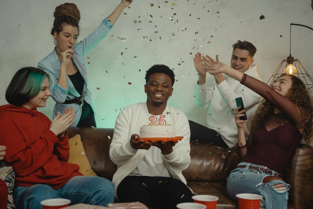 Young African man laughing and celebrating his birthday with close friends.